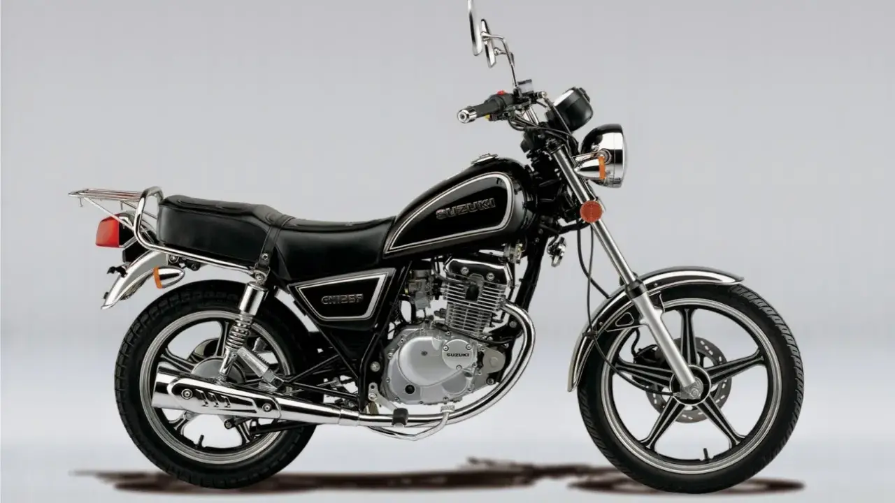 Czarny motocykl Suzuki GN 125 z chromowanymi elementami, siedzeniem pasażera i bagażnikiem.