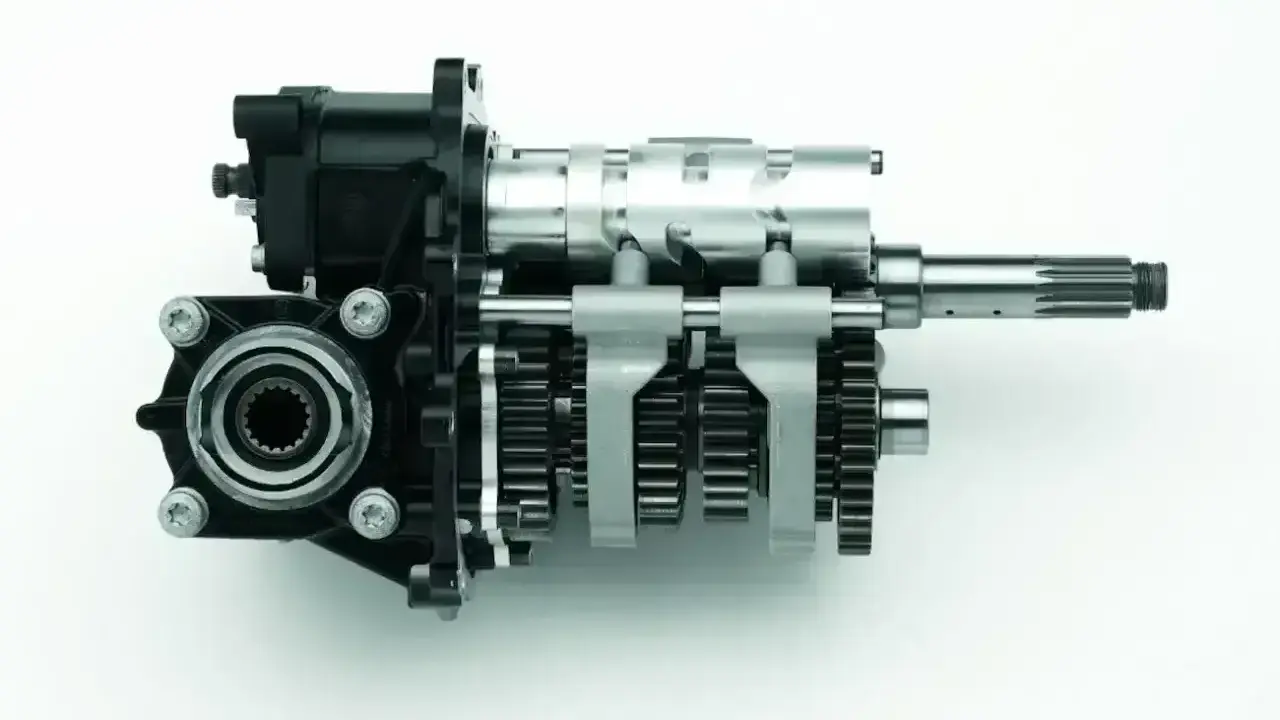 Rysunek przedstawia mechanizm skrzyni biegów w motorze, z widocznymi wałkami i zębatkami.