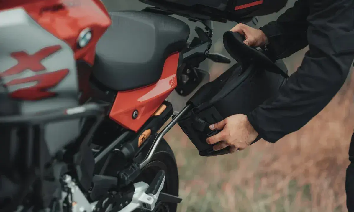 Przygotowanie do wyprawy: montaż sakwy do motocykla na malownicze **trasy motocyklowe Wielkopolska**.