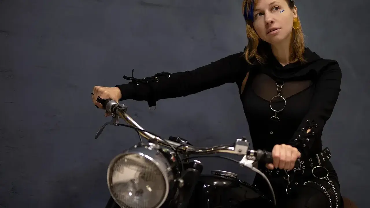 Kobieta na motocyklu, gotowa na odkrywanie tras motocyklowych zachodniopomorskie. Stylowy strój i pewność siebie.