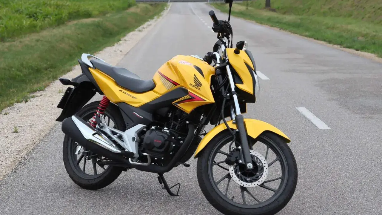 Żółty motocykl Honda CBF 125F na drodze. Poznaj honda cbf 125 dane techniczne i możliwości tego zwinnego jednośladu.