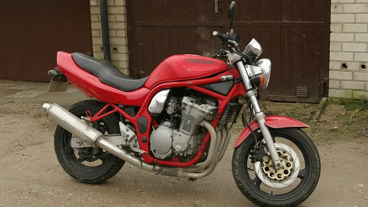 Czerwony Suzuki Bandit 600, gotowy do jazdy, z widocznym silnikiem i wydechem.