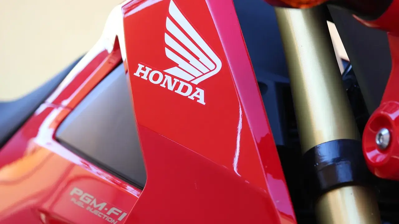 Czerwony motocykl Honda z logo i napisem PGM-FI. Pamiętaj o regularnych przeglądach motocykla 125!