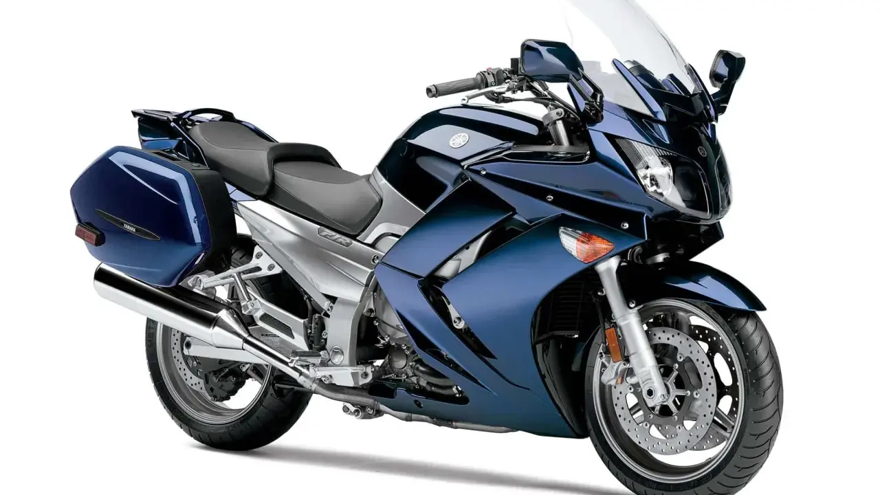 Granatowy motocykl Yamaha FJR 1300, z kuframi. Wady tego modelu to m.in. wysoka cena i waga.