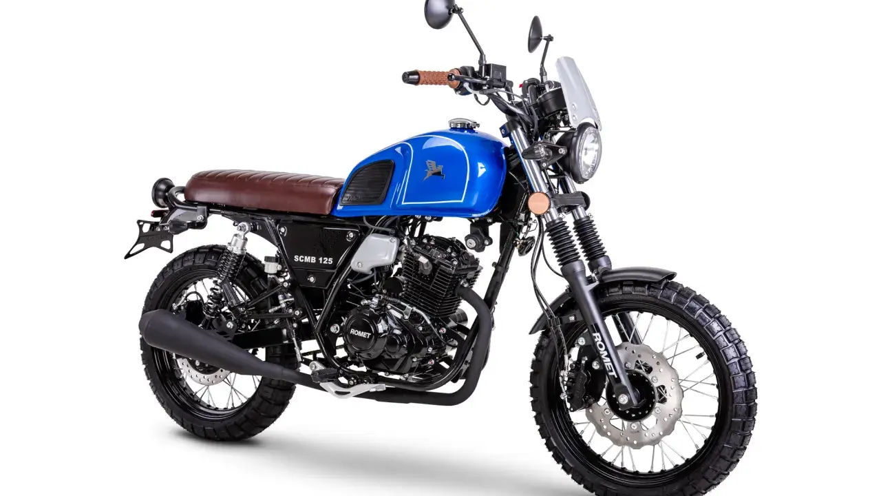 Niebieski motocykl Romet SCMB 125 w stylu scrambler, z brązowym siedzeniem i oponami terenowymi.