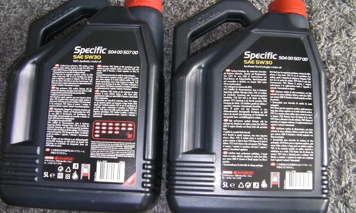 Dwie czarne bańki oleju silnikowego Motul Specific SAE 5W30. Sprawdzenie oryginalności produktu jest kluczowe.