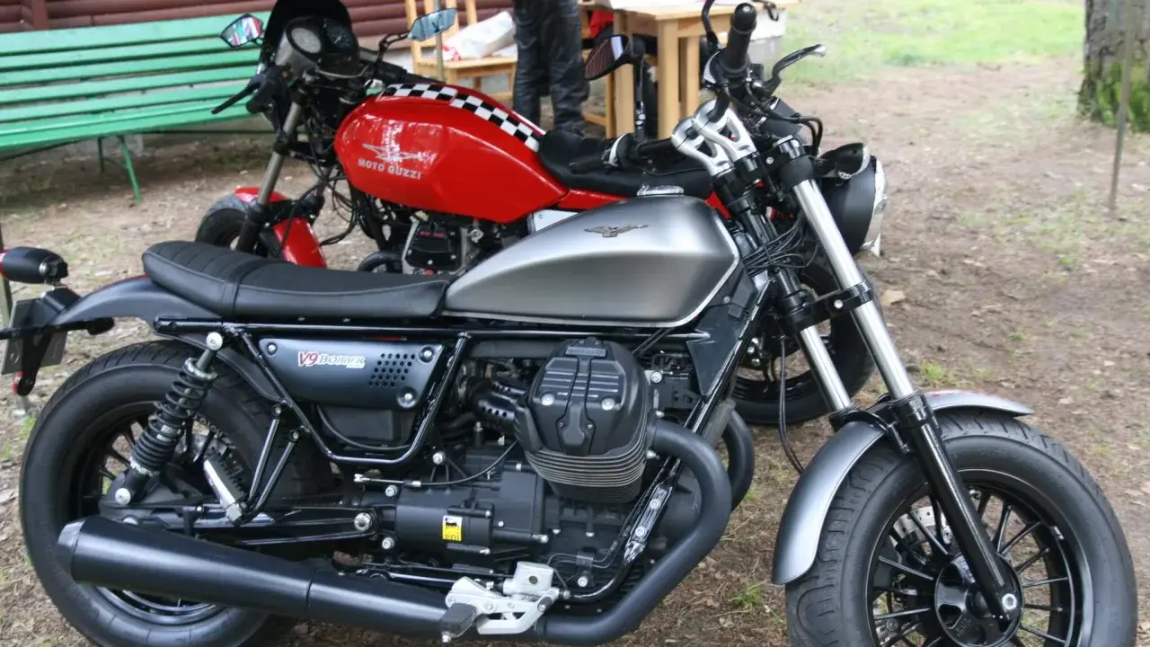 Dwa motocykle Moto Guzzi, jeden srebrny, drugi czerwony z szachownicą. Może to przypomnienie o opłacie skarbowej za motocykl z zagranicy.