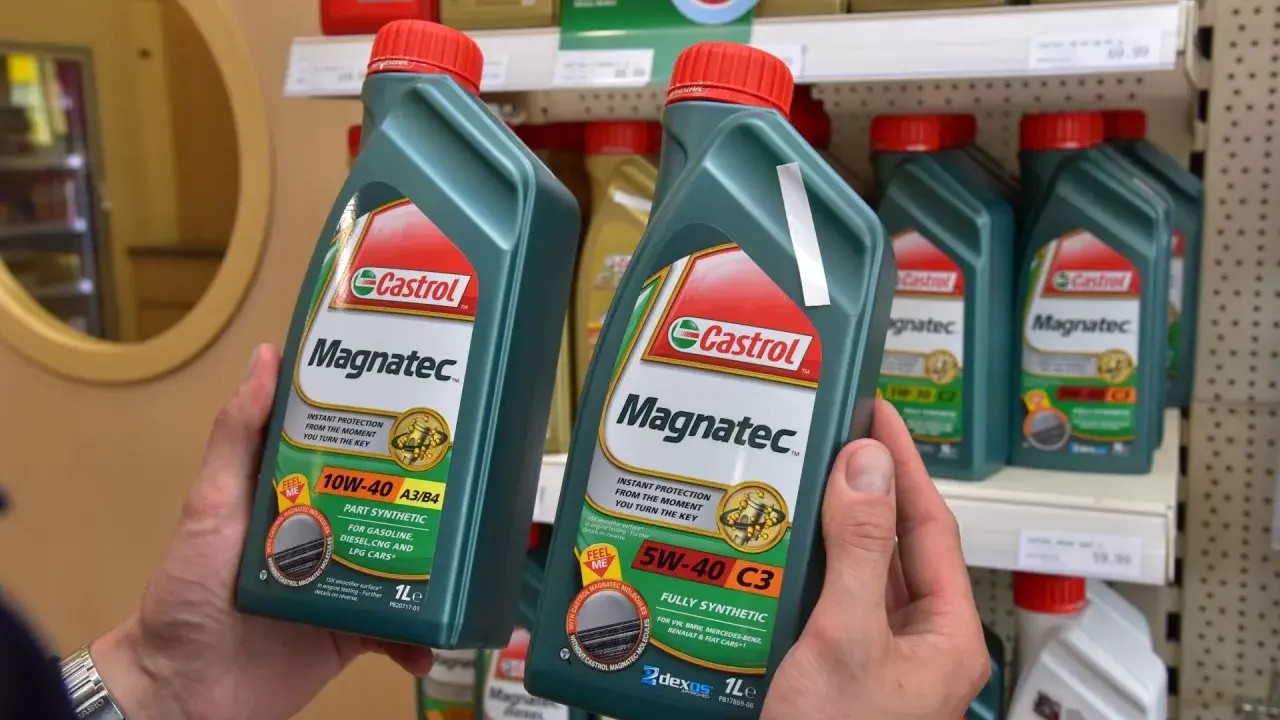 Ręce trzymają butelki oleju silnikowego Castrol Magnatec. Czy Castrol to dobry olej? Ten produkt zapewnia natychmiastową ochronę silnika.