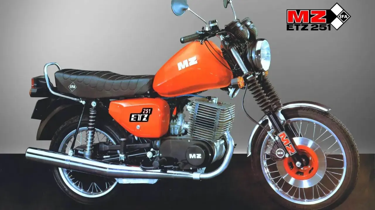 Pomarańczowy motocykl MZ ETZ 251 z widocznymi danymi technicznymi. Klasyk z NRD, gotowy do jazdy.