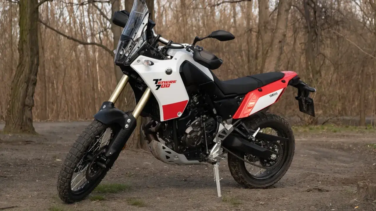 Yamaha Tenere 700 waga idealna na wyprawy. Motocykl stoi na leśnej ścieżce, gotowy do przygody.