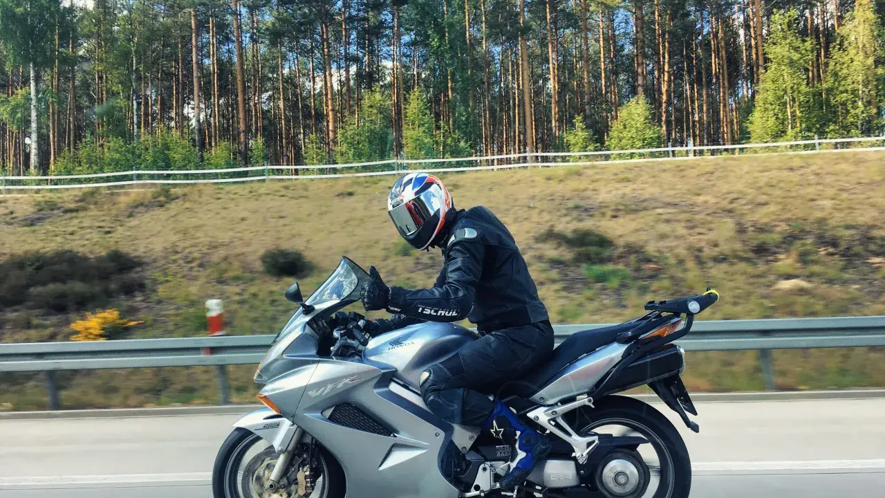 Motocyklista na srebrnej Hondzie VFR 800, mimo że to świetna maszyna, ma swoje wady. Jazda po lesie.