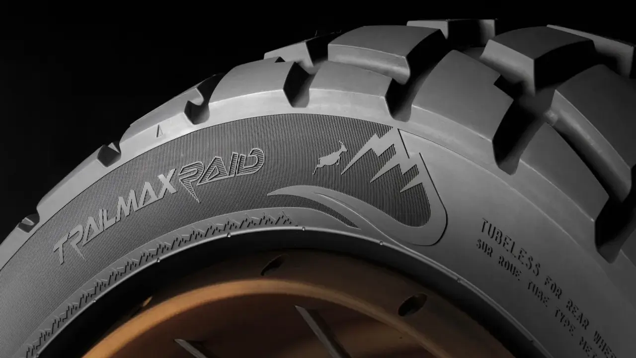 Opona motocyklowa Dunlop Trailmax Raid z agresywnym bieżnikiem i grafiką górską, gotowa na każdą wyprawę.