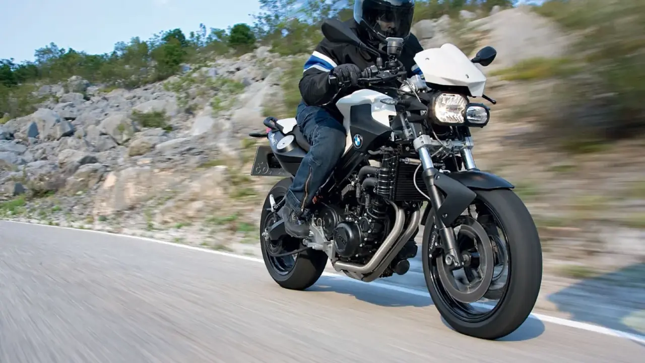 Motocyklista w kasku jedzie na BMW F800R po krętej drodze. Poznaj jego dane techniczne.