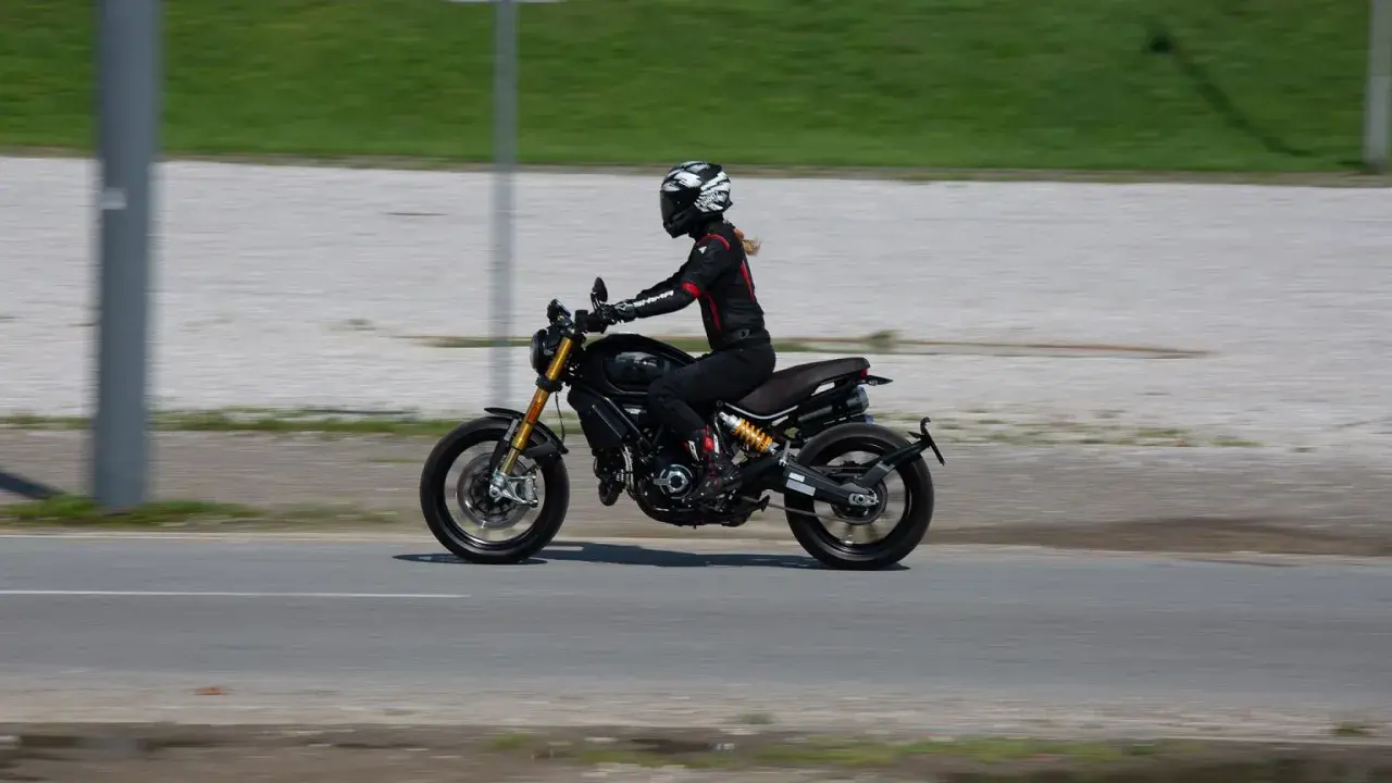 Kobieta w kasku i kombinezonie jedzie motocyklem spełniającym normę **euro 4**.