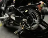 Zbliżenie na tylne koło motocykla z widocznym łańcuchem i zębatką. Pytanie: jaki smar do łańcucha motocyklowego?
