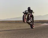 Motocyklista na torze wykonuje wheelie. System kontroli trakcji co to? Pomaga utrzymać przyczepność podczas takich manewrów.