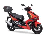 Czerwony skuter z czarnym siedzeniem i kufrem. Do jakiej pojemności można jeździć motorem bez prawa jazdy? Ten model to świetny wybór!