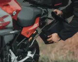 Przygotowanie do wyprawy: montaż sakwy do motocykla na malownicze **trasy motocyklowe Wielkopolska**.