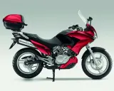 Czerwony motocykl Honda Varadero 125 z kufrem, gotowy na odblokowanie mocy i przygodę.
