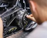 Mechanik pracuje nad mechanizmem motocykla, który umożliwia zmianę biegów bez sprzęgła.