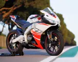 Sportowy motocykl Aprilia RS 125 2T, biało-czerwony, z widocznymi detalami i napisem "RS". Idealny do poznania jego aprilia rs 125 2t dane techniczne.