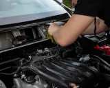 Mechanik sprawdza, dlaczego przekaźnik cyka, a rozrusznik nie kręci. Widok na silnik i przewody.