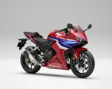 Sportowy motocykl Honda seria CBR w czerwono-niebiesko-białych barwach, gotowy do dynamicznej jazdy.