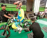 Mechanik sprawdza ustawienie sag w motocyklu, pomagając zawodnikowi w przygotowaniach do wyścigu.