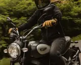 Motocyklista w kasku i żółtych rękawicach jedzie motocyklem. Zastanawia się, przy jakich obrotach zmieniać biegi, by jazda była płynna.