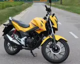 Żółty motocykl Honda CBF 125F na drodze. Poznaj honda cbf 125 dane techniczne i możliwości tego zwinnego jednośladu.