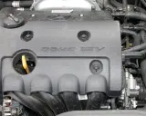 Silnik samochodowy z napisem DOHC 16V. DOHC to skrót od "Double Overhead Camshaft", co oznacza podwójny wałek rozrządu umieszczony nad głowicą.