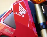 Czerwony motocykl Honda z logo i napisem PGM-FI. Pamiętaj o regularnych przeglądach motocykla 125!
