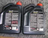 Dwie czarne bańki oleju silnikowego Motul Specific SAE 5W30. Sprawdzenie oryginalności produktu jest kluczowe.