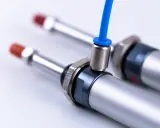 Pneumatyczne siłowniki z niebieskim przewodem. Montaż tłoka w cylindrze jest kluczowy dla ich działania.