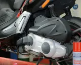Skuter Gilera z widocznym elementem napędowym. Puszka środka do czyszczenia hamulców obok sugeruje problemy, być może związane z zużytym wariatorem w skuterze objawy.