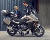 Para zwiedzająca motocykle z automatyczną skrzynią biegów. Nowoczesny design i praktyczne kufry zachęcają do wspólnych podróży.