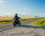 Motocyklista na tle pól pszenicy, odkrywa malownicze trasy motocyklowe mazowieckie.