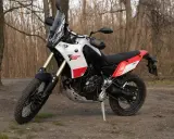 Yamaha Tenere 700 waga idealna na wyprawy. Motocykl stoi na leśnej ścieżce, gotowy do przygody.