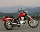 Czerwony motocykl Kawasaki EN 500 na tle górskich krajobrazów. Dane techniczne tego modelu to świetny wybór dla miłośników klasycznych cruiserów.