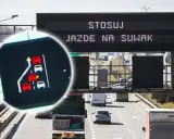 Zbliżenie na ekran z grafiką samochodów i znak drogowy z napisem "STOSUJ JAZDĘ NA SUWAK".