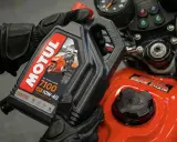 Rękawice motocyklowe trzymają olej Motul 7100 10W-40. Sprawdź, co ile wymieniać olej w motocyklu, by zapewnić mu długą żywotność.
