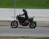 Kobieta w kasku i kombinezonie jedzie motocyklem spełniającym normę **euro 4**.