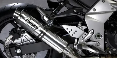 Błyszczący tłumik motocyklowy Hurric, element układu wydechowego, który może pomóc w uzyskaniu basowego brzmienia.