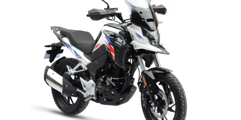 Nowy motocykl 125cc gotowy do docierania. Biało-czarny z czerwono-niebieskimi akcentami, z wysoką szybą i bagażnikiem.