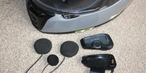 Montaż interkomu w kasku motocyklowym. Zestaw zawiera moduł główny Cardo, słuchawki i mikrofon.