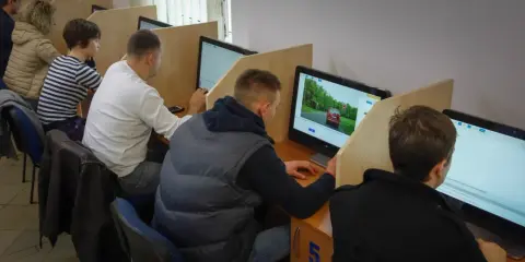 Uczestnicy kursu na prawo jazdy sprawdzają, ile błędów można zrobić na egzaminie teoretycznym, siedząc przy komputerach.
