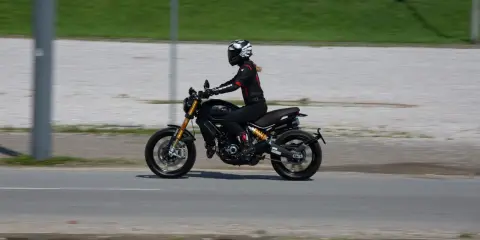 Kobieta w kasku i kombinezonie jedzie motocyklem spełniającym normę **euro 4**.