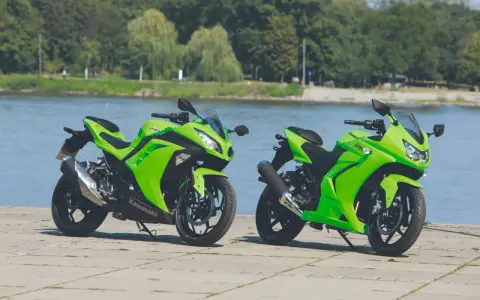 Dwa zielone Kawasaki Ninja 250 stoją nad wodą. Poznaj kawasaki ninja 250 dane techniczne i poczuj moc!
