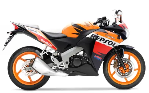 Pomarańczowo-czarny motocykl Honda CBR 125R w barwach Repsol, gotowy do jazdy z mocą V-max.