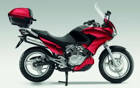 Czerwony motocykl Honda Varadero 125 z kufrem, gotowy na odblokowanie mocy i przygodę.